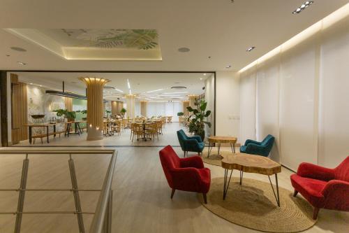 a lobby with chairs and tables and a restaurant at Hotel Soratama in Pereira
