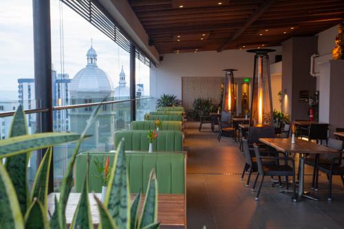 a restaurant with tables and chairs and a view of the city at Hotel Soratama in Pereira