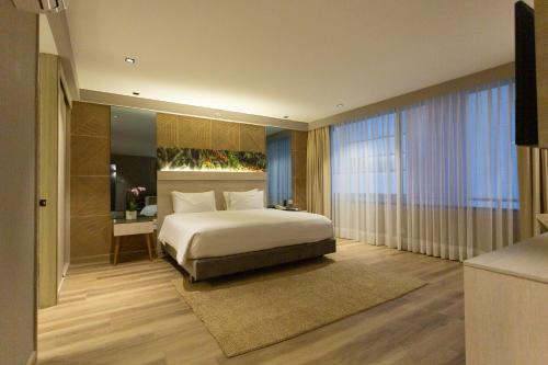 a bedroom with a bed and a large window at Hotel Soratama in Pereira