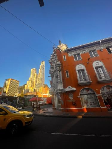 a yellow car parked on a city street with buildings at Hotel Artistico in Bogotá