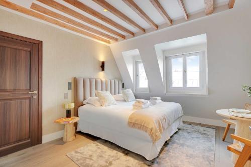 - une chambre avec un lit blanc et un plafond en bois dans l'établissement Stylish Studio - 2P - Vendôme Square, à Paris