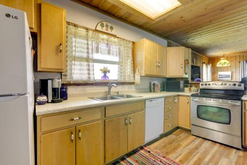 a kitchen with wooden cabinets and a sink and a stove at Scenic Mount Sopris View Historic Alpine Cabin! in Glenwood Springs