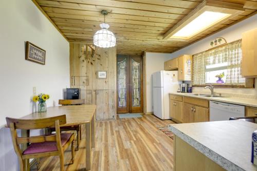 a kitchen with a table and a refrigerator at Scenic Mount Sopris View Historic Alpine Cabin! in Glenwood Springs