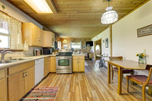 a kitchen with wooden cabinets and a table and a dining room at Scenic Mount Sopris View Historic Alpine Cabin! in Glenwood Springs