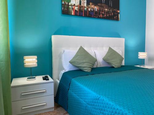 a blue bedroom with a bed and a blue wall at venice popular residence in Mestre