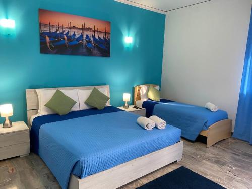 a bedroom with two beds with blue walls at venice popular residence in Mestre