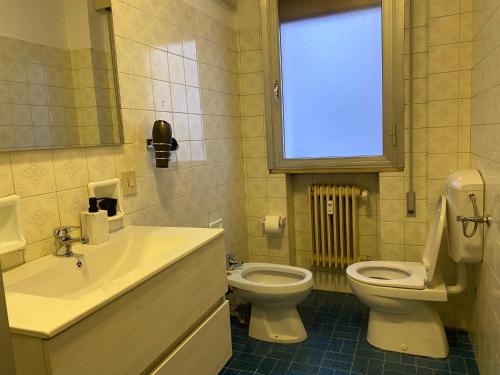 a bathroom with a sink and a toilet and a window at venice popular residence in Mestre