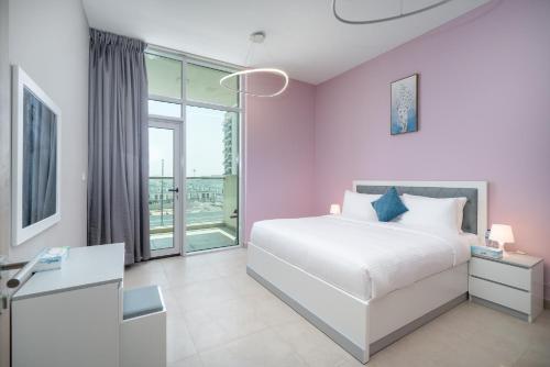 ein Schlafzimmer mit einem weißen Bett und einem großen Fenster in der Unterkunft Trinity Holiday Homes - Spacious Modern Living 2BR Unique Apartment in Dubai