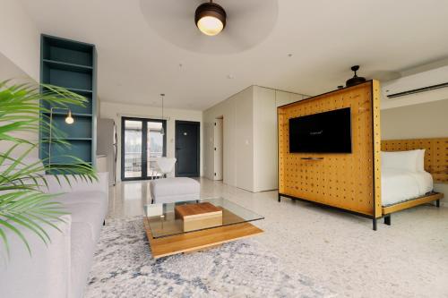 a living room with a bed and a tv and a couch at La Moderna by Wynwood House in Panama City