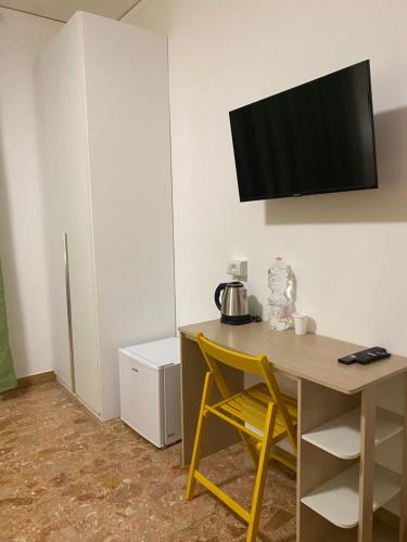 a room with a desk with a television on the wall at venice popular residence in Mestre