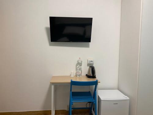 a table with a blue chair and a television on a wall at venice popular residence in Mestre