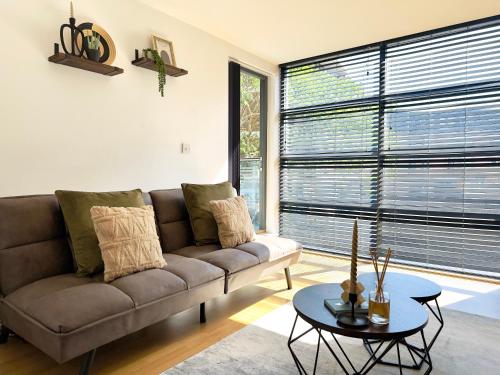 a living room with a couch and a large window at City Centre Apartment Near the University and Bodleian Library in Oxford