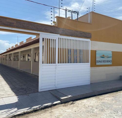 a building with a white garage door on the side of it at Dunas residence casa 15- Lençois Maranhense in Santo Amaro