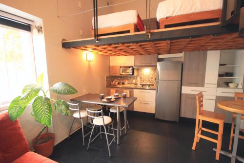 eine Küche mit einem Tisch und Stühlen sowie ein Hochbett in der Unterkunft Hotel del Refugio in Guadalajara