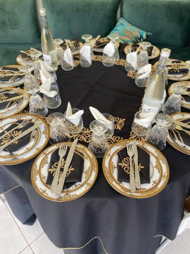 a table with plates and wine glasses on it at Gîte Jnane fès in El Jadida