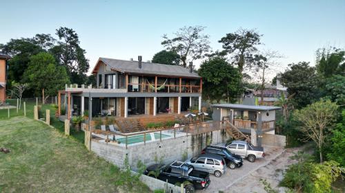 een huis met drie auto's ervoor geparkeerd bij VENTO TERRAL SURF STUDIOS in Imbituba