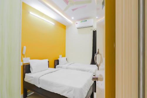 2 camas en una habitación de hospital con paredes amarillas en Home Sri Balaji Luxary Rooms Near Inorbit Mall Cyberabad en Gachibowli