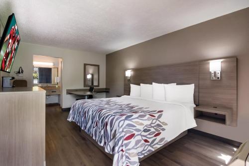 a hotel room with a bed and a desk at Red Roof Inn Vero Beach - I-95 in Vero Beach