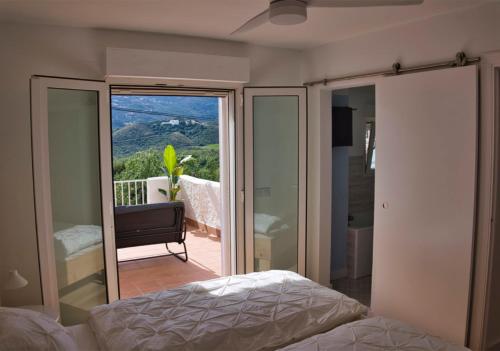a bedroom with a bed and a view of a balcony at Casa de KoKo in Turre