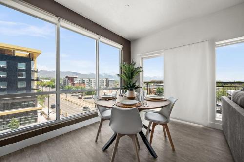 a dining room with a table and chairs and large windows at LUX 2 BD BOHO in heart of SLC in Salt Lake City