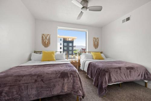 two beds in a room with a window at LUX 2 BD BOHO in heart of SLC in Salt Lake City