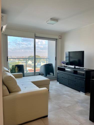 a living room with a couch and a flat screen tv at Departamento céntrico en Rafaela in Rafaela