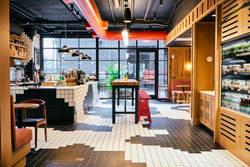 a restaurant with a bar with a table and chairs at The Junto Hotel in Columbus