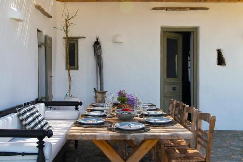a wooden table with plates and bowls on it at Sifnos Themonies in Apollonia