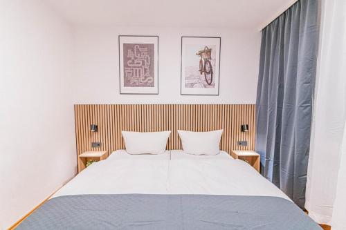 una camera da letto con un grande letto con due cuscini di Hotel Solinger Hof a Solingen