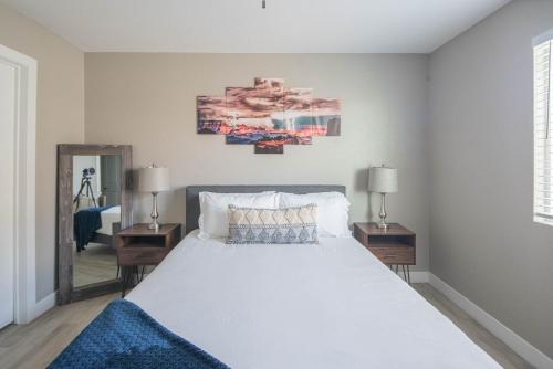 a bedroom with a large white bed with two lamps at Resort-style home with pool in Phoenix minutes from State Farm Stadium! in Phoenix