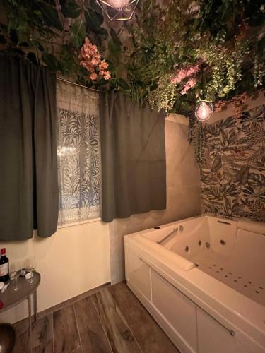 a bathroom with a tub and flowers on the ceiling at A due passi da in Formia