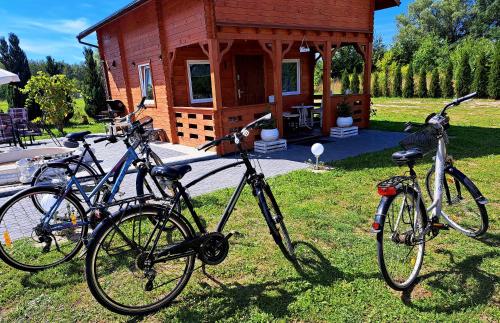 two bikes parked in the grass in front of a cabin at Noclegi "LAS WYPAS" 2 Domki drewniane całoroczne, oraz 1 Apartament dla dwojga - wynajem in Trzcianka