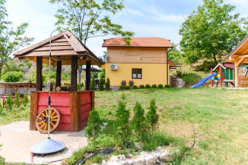 a backyard with a play kitchen and a house at Green House Latin Grad in Vrmdža