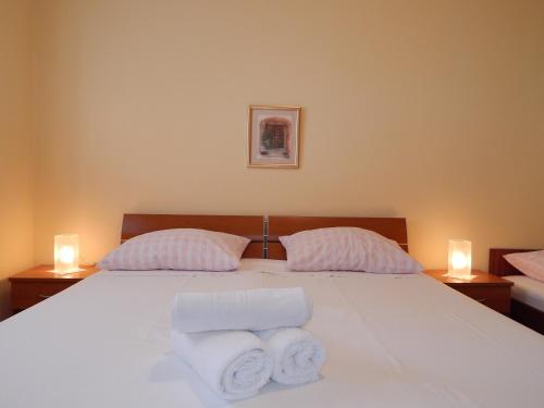 a bedroom with a white bed with two pillows and two candles at Villa Maristika in Omiš