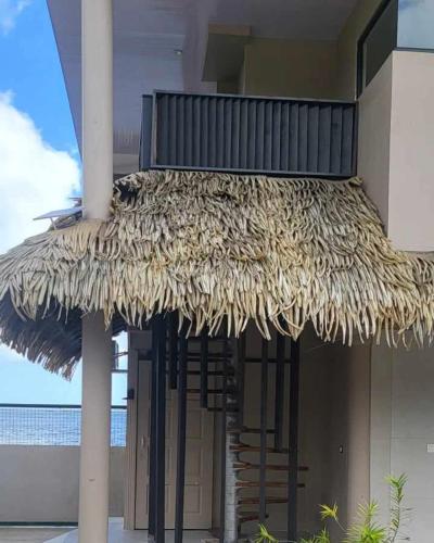 a large straw umbrella on the side of a building at Le Village de Vairao in Vairao