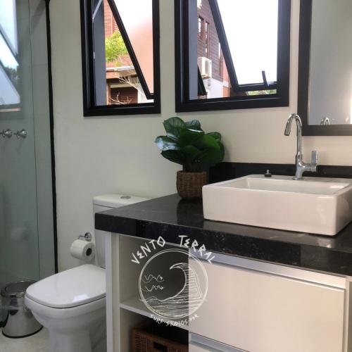 a bathroom with a sink and a toilet at VENTO TERRAL SURF STUDIOS in Imbituba