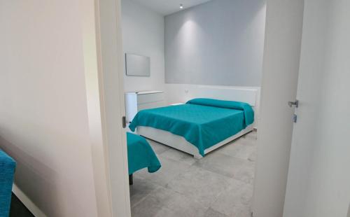 a bedroom with a bed with a blue blanket at Al Vicolo in Acireale