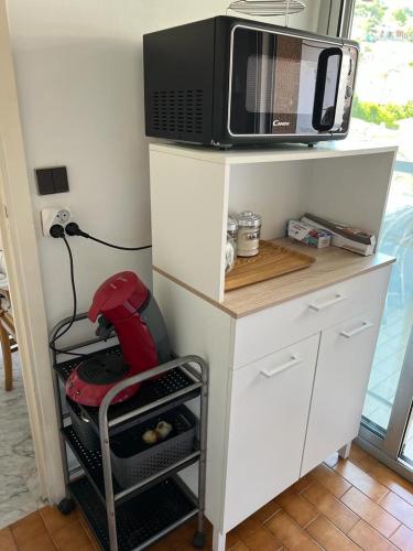 un four micro-ondes installé au-dessus d'un comptoir de cuisine dans l'établissement Studio avec grand balcon - Roquebrune Cap-Martin proche Menton et Monaco, à Roquebrune-Cap-Martin