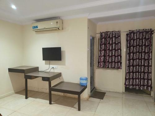 a room with a desk and a television on a wall at Collection O 81233 Mr Residency in Hyderabad