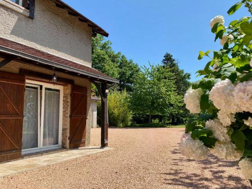a front door of a house with white flowers at Le Mas aux Papillons in Vendat