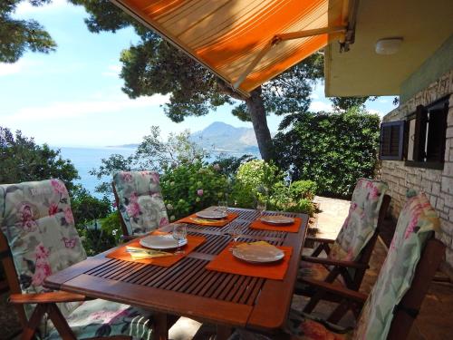 a wooden table and chairs on a patio at Villa Maristika in Omiš