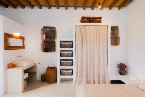 a bathroom with a shower curtain and a sink at Sifnos Themonies in Apollonia