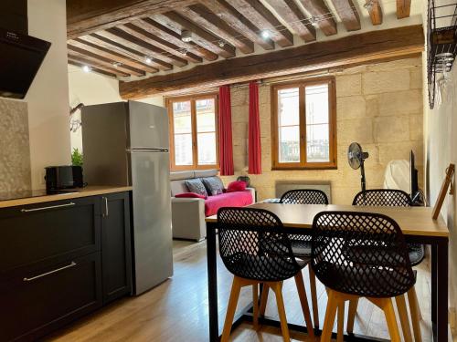 a kitchen and living room with a table and chairs at Appartements chez Delphine et Guillaume au coeur de Semur en Auxois in Semur-en-Auxois