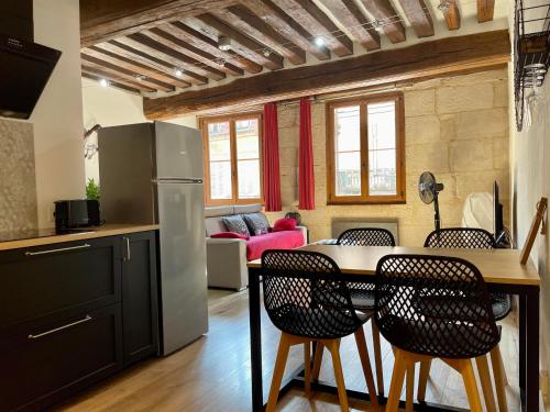 une cuisine et un salon avec une table et des chaises dans l'établissement Appartements chez Delphine et Guillaume au coeur de Semur en Auxois, à Semur-en-Auxois