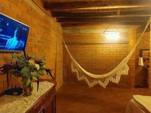 een kamer met een televisie en een vaas met bloemen op een toonbank bij Casa del Rio in the Andes in Gualaceo