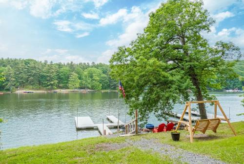 a dock with a swing and a boat on a lake at Dreamers Inn in Swanton