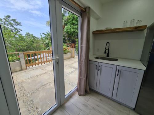 a kitchen with a sink and a sliding glass door at Casa Colibri in Roatan