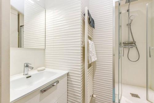 une salle de bain blanche avec un lavabo et une douche dans l'établissement 44 Foch - 1, à Grenoble