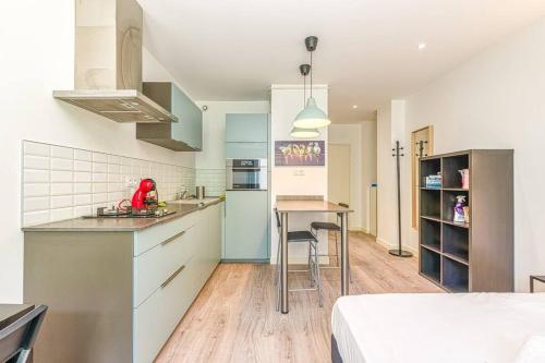 - une cuisine avec des armoires bleues et une table dans une pièce dans l'établissement 44 Foch - 1, à Grenoble