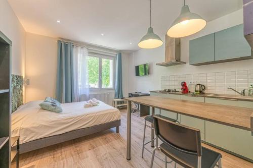 - une cuisine avec un lit et une table avec des chaises dans l'établissement 44 Foch - 1, à Grenoble